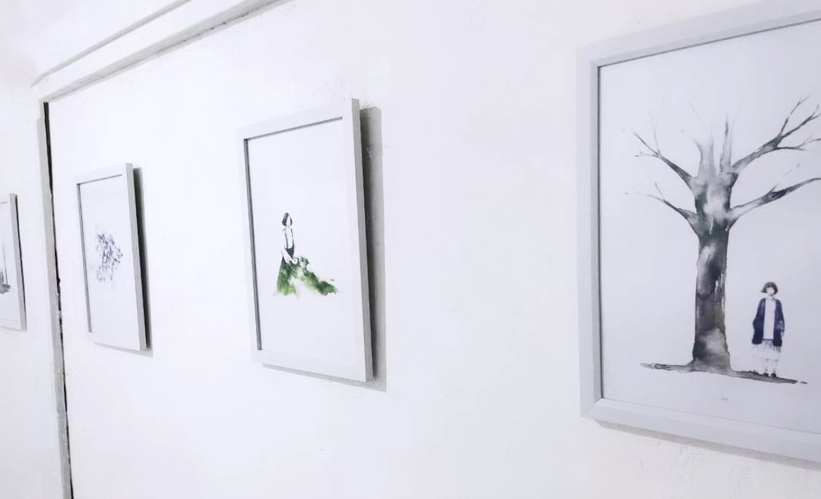 Close view of the REFLECT|ON watercolor series on a white gallery wall