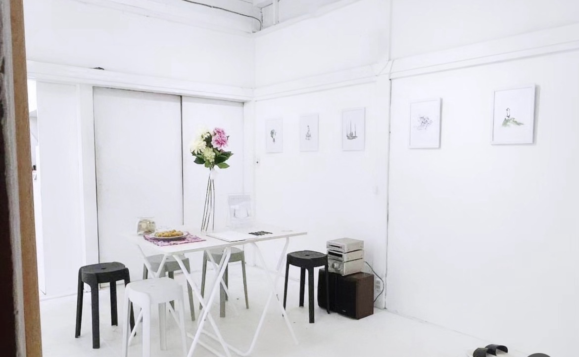 REFLECT|ON exhibition table, flowers and framed works