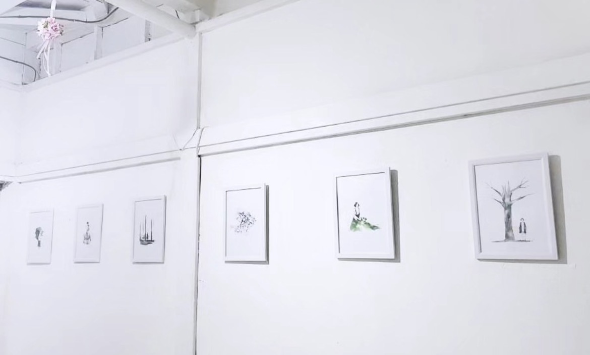 Long gallery wall displaying the REFLECT|ON watercolor series