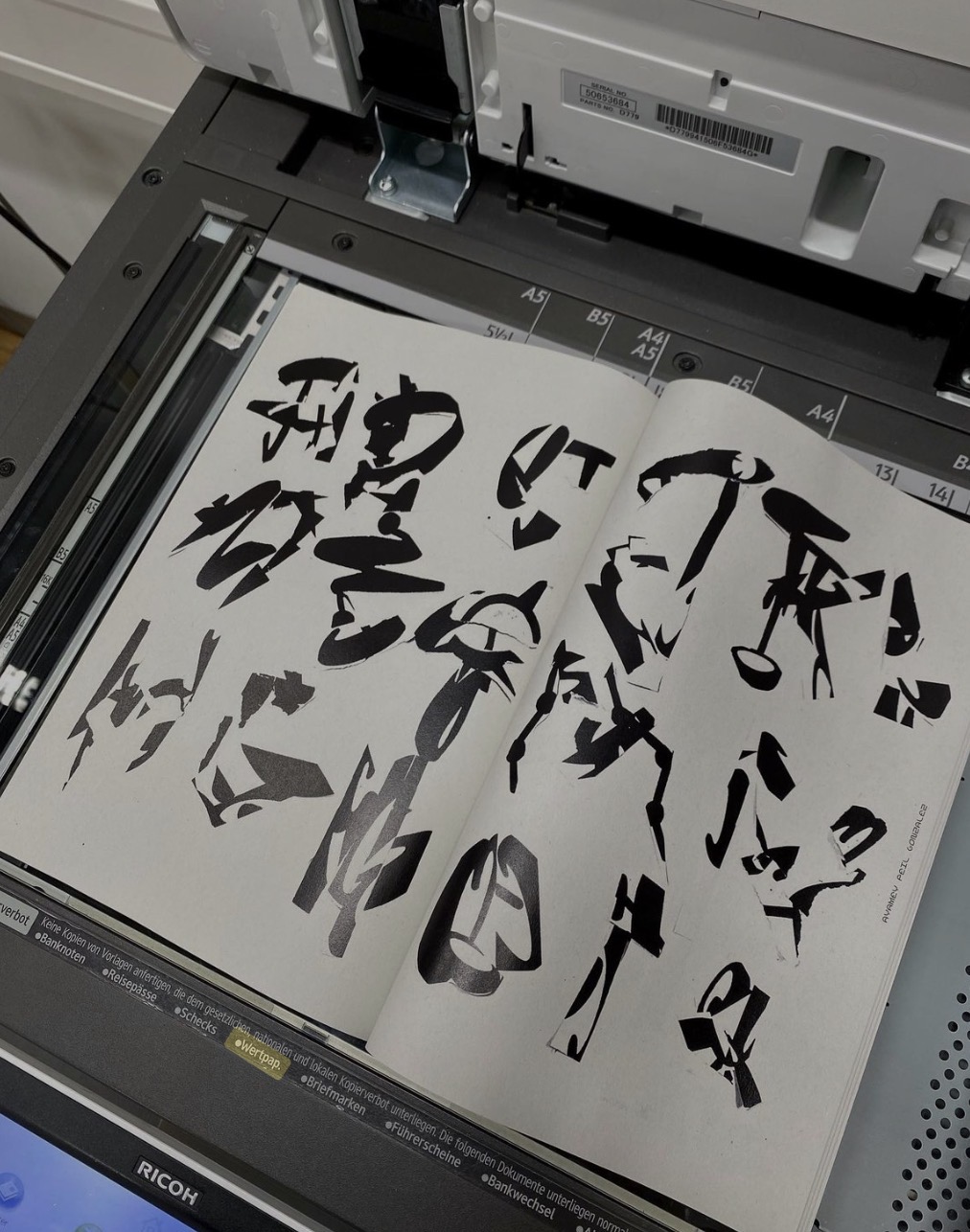 A book of experimental letterforms being copied on a photocopier