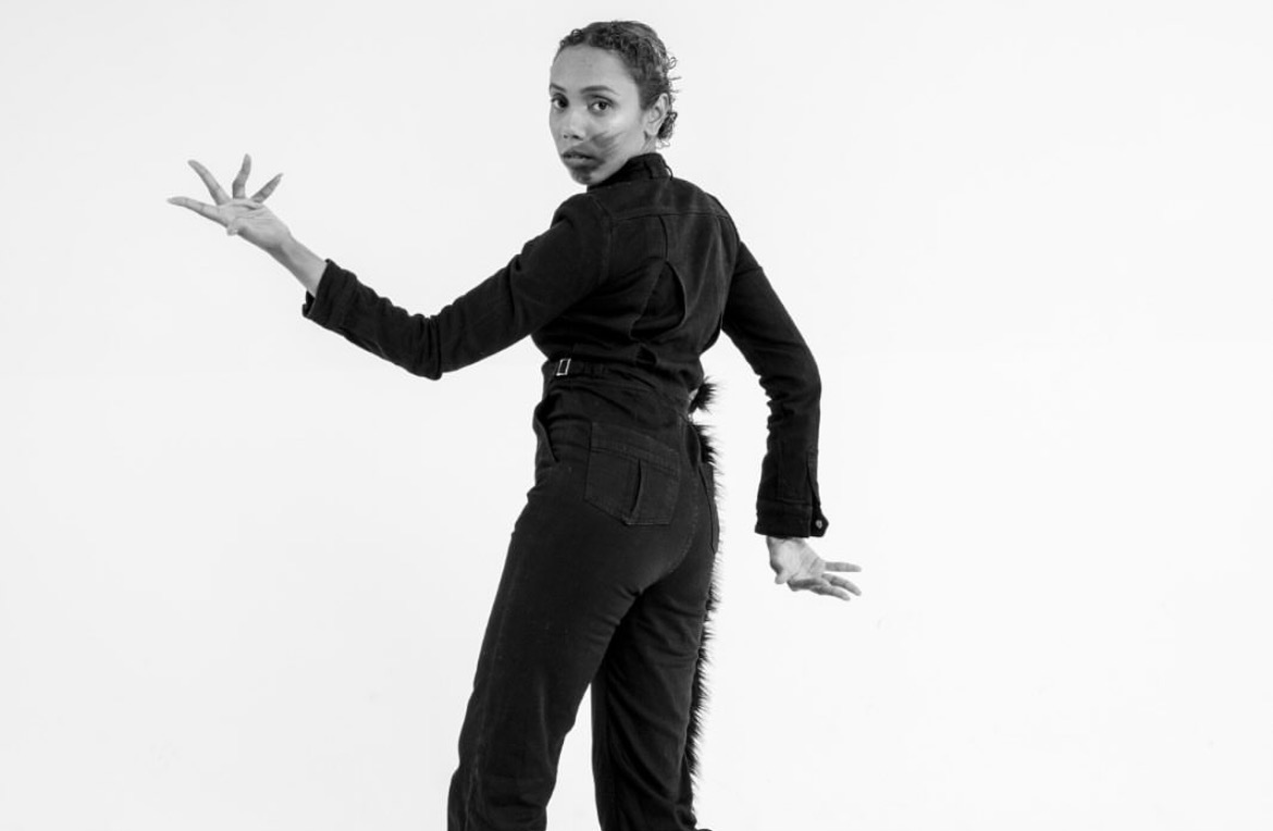 Solo performer looking back over one shoulder in black and white