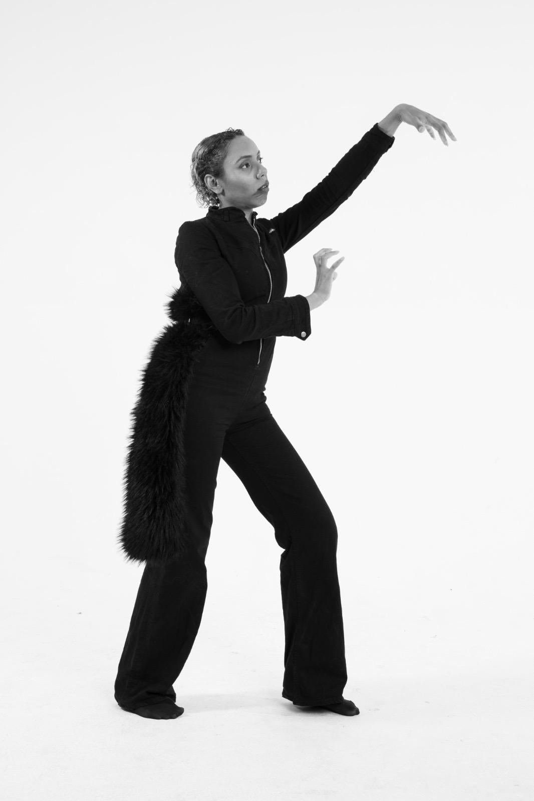 Solo performer lifting one arm in a full-body gesture