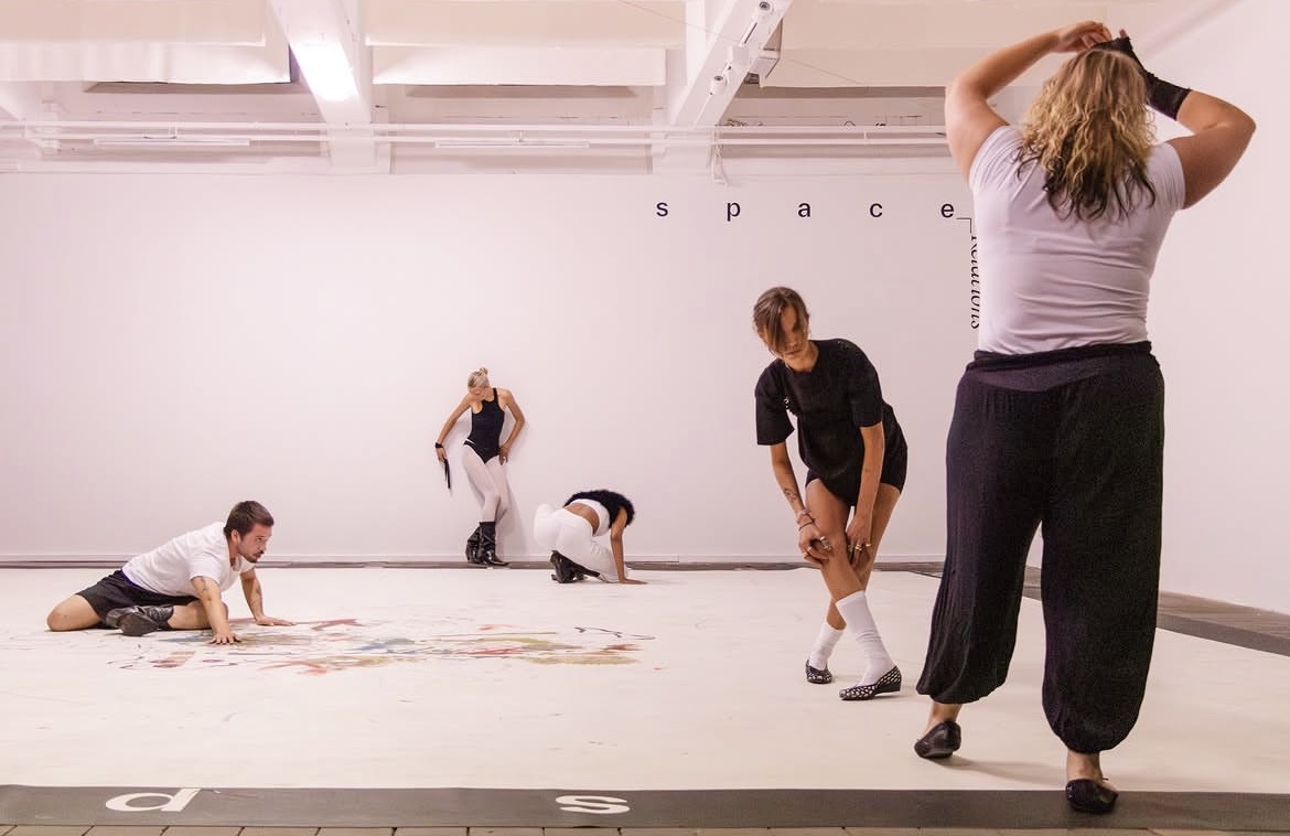Five performers moving across the Weltkunstzimmer gallery floor
