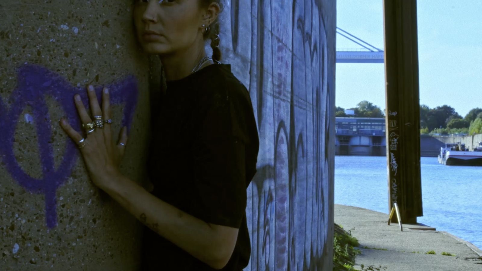 Performer pressing a hand against a concrete wall